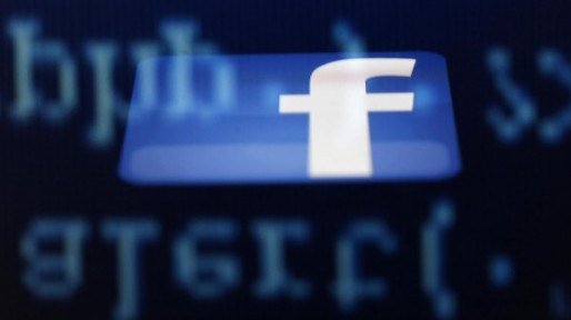 File photo illustration of a Facebook logo on an Ipad reflected among source code on the LCD screen of a computer